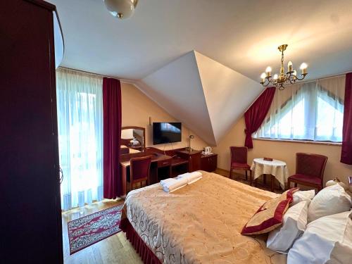 a bedroom with a bed and a desk in a room at Pensjonat Szach in Krynica Zdrój