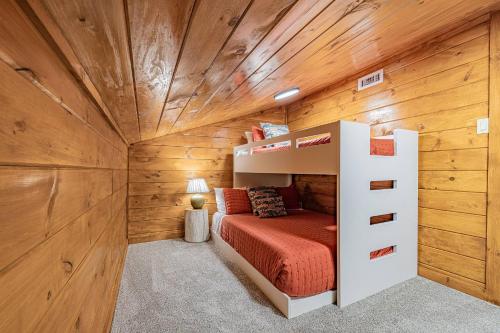 a bedroom with a bunk bed and wooden walls at Fall Break+Family Cabin+Game Room+Fire Pit+Hot Tub in Wear Valley