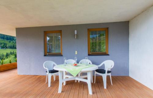 a dining room with a white table and chairs at Bergadler in Iselsberg