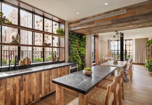 a dining room with a table and chairs and windows at 1 Hotel Central Park in New York
