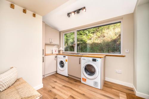 a laundry room with a washer and dryer and a window at The Top House, Lothmore in Helmsdale