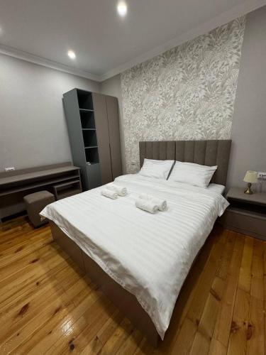 a bedroom with a large white bed with towels on it at Hotel 002 in Osh
