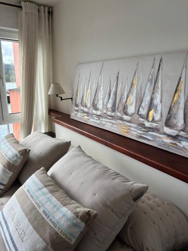 a bedroom with two beds and a wall with a picture of sailboats at El rincón de Carolina in O Barqueiro