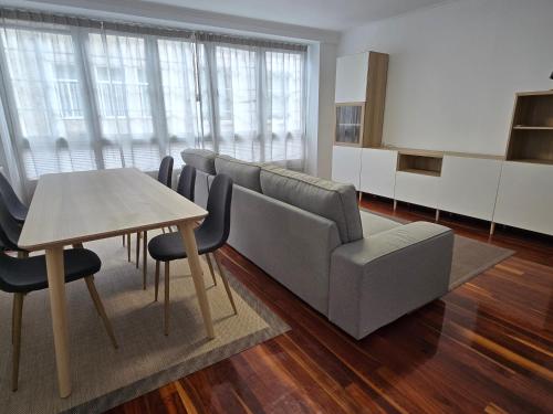 a living room with a couch and a table and chairs at Apartamento Lugo centro muralla in Lugo
