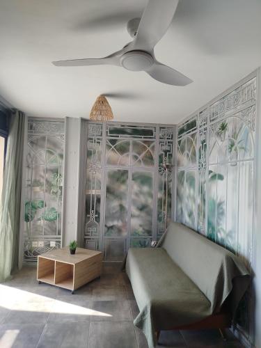 a living room with a couch and a ceiling fan at Le lagon de Stella in Saint-Leu