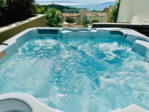 a jacuzzi tub with blue water in it at Luxury Adria Sea City & Whirpool, Mountain View Apartment in Makarska