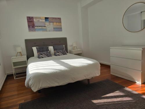 a bedroom with a bed with a dresser and a mirror at Apartamento Lugo centro muralla in Lugo