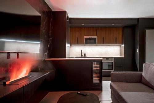a living room with a fireplace and a couch at Obsidian Luxury Suite - balnéo, miroirs aux plafonds, proche disney in Montévrain