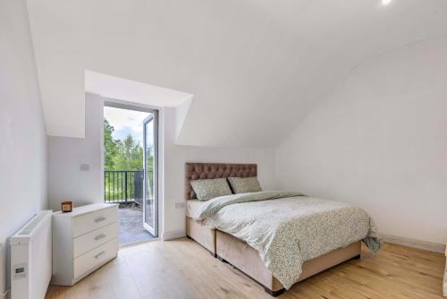 モナハンにあるRooftop Apartmentの白いベッドルーム(ベッド1台、バルコニー付)