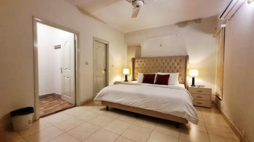 a bedroom with a large white bed and a window at Haven Lodge - 4BR Luxurious Spanish Villa in Lahore in Lahore