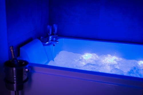an aquarium in a bathroom with a view of the sky at Obsidian Luxury Suite - balnéo, miroirs aux plafonds, proche disney in Montévrain