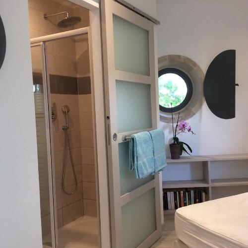 a bathroom with a shower and a glass door at Hexagonal Tower for 2 with shared pool in Semur-en-Auxois