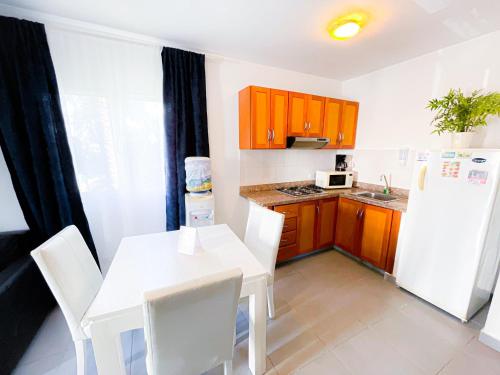 a kitchen with a white table and a white refrigerator at Caribbean Mojito Studios HOTEL WiFi Los Corales BEACH CLUB & SPA in Punta Cana