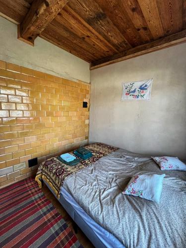 a bed in a room with a brick wall at Agroturystyka Prynuka in Skroblaki