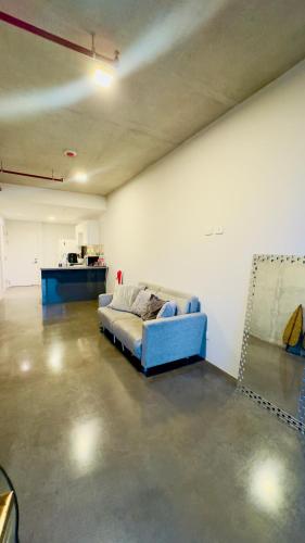 a living room with a blue couch in a room at Bosque Cósmico en la ciudad in San José