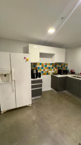 an empty room with a refrigerator and a kitchen at Bosque Cósmico en la ciudad in San José