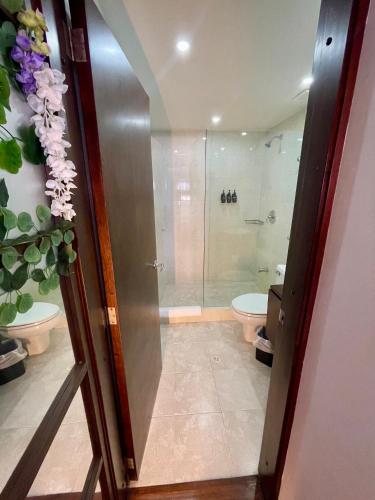 a bathroom with a shower and a toilet at Unicentro Rooms Inn by Saint Michel in Bogotá