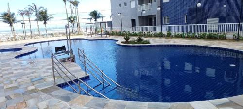 een groot zwembad voor een gebouw bij Ape Condomínio Club - pé na areia in Mongaguá