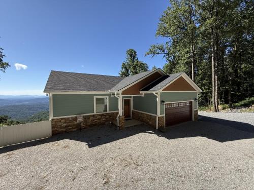 a house with a garage on a gravel driveway at Solomon’s Seal - Full Home in Spruce Pine