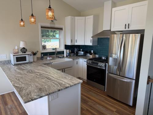 a kitchen with white cabinets and stainless steel appliances at Solomon’s Seal - Full Home in Spruce Pine