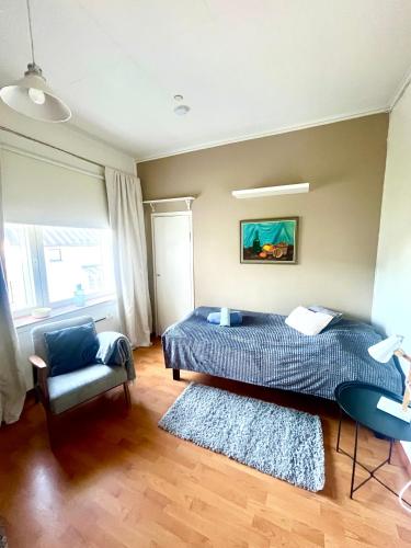 a bedroom with a bed and a chair at Snygg studio lägenhet Wolffskavägen 21 in Vaasa