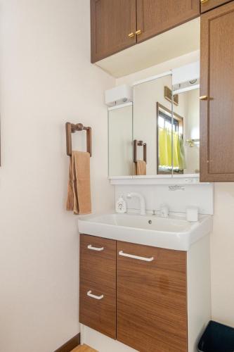 a bathroom with a sink and a mirror at グループ宿泊に最適 Spacious Home Base by Yadoya in Yokkaichi