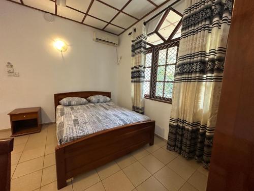 a bedroom with a bed and a window at Wonder Apartments in Negombo