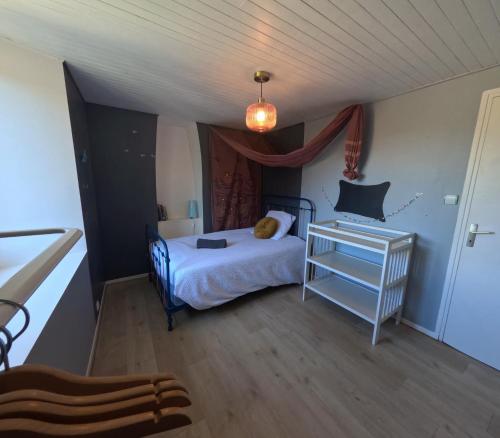 ein kleines Schlafzimmer mit einem Bett und einem Tisch in der Unterkunft La Belmontine Maison avec jardin Uriage-les-Bains in Vaulnaveys-le-Haut