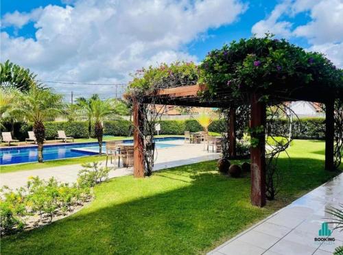 a garden with a pergola and a swimming pool at Apartamento com 2 quartos próximo aCastelão Arena in Fortaleza