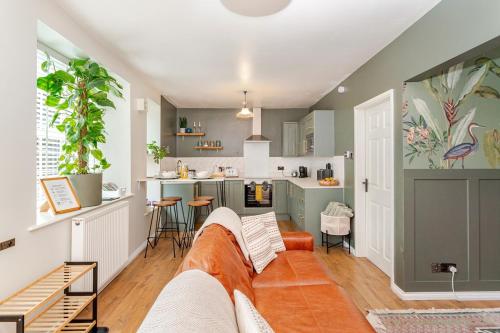 a living room with a couch and a kitchen at The Burrow - 2 bedroom apartment in central Windermere in Windermere