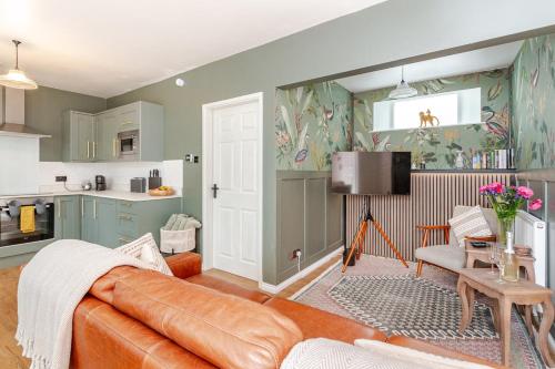 a living room with a couch and a kitchen at The Burrow - 2 bedroom apartment in central Windermere in Windermere
