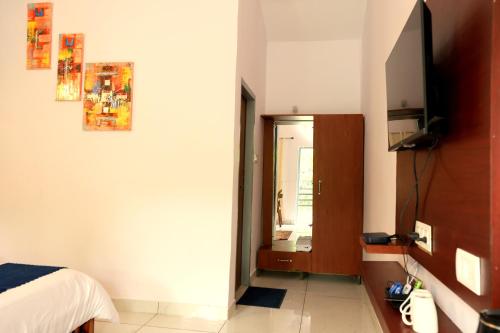 a bedroom with a bed and a mirror at Aranya Resort & Suites By Shivaneel Hospitality in Rāmnagar