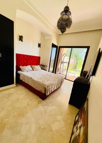 a bedroom with a bed with a red headboard at Kridarek - Magnifique Villa avec piscine à Marrakech in Douar bel Rhanodour