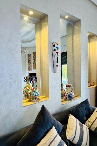 a living room with a couch and three mirrors at Kridarek - Magnifique Villa avec piscine à Marrakech in Douar bel Rhanodour