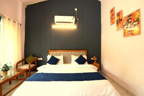a bedroom with a white bed and a black wall at Aranya Resort & Suites By Shivaneel Hospitality in Rāmnagar