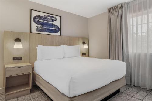 a bedroom with a large white bed and a window at Sonesta Simply Suites Boston Burlington in Burlington