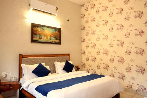 a bedroom with a bed and a wall with flowers at Aranya Resort & Suites By Shivaneel Hospitality in Rāmnagar