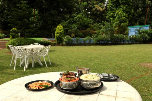 a table with plates of food on top of it at Aranya Resort & Suites By Shivaneel Hospitality in Rāmnagar