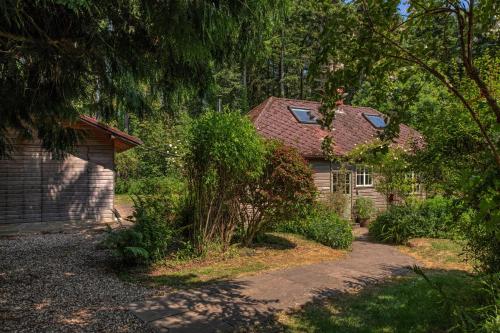 a house with a red roof and a driveway at Tranquil Woodland Cottage, 10-Min Drive to Clifton in Pill