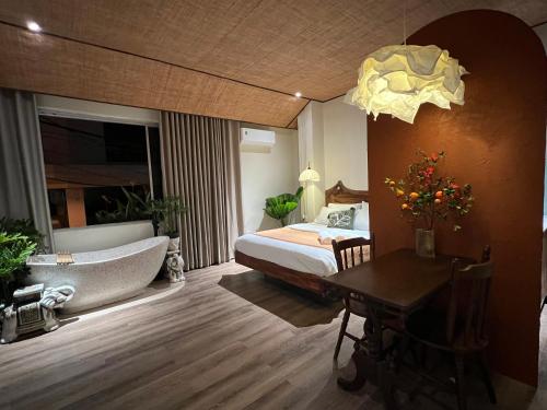 a bedroom with a bed and a tub and a table at PINhome in Ho Chi Minh City