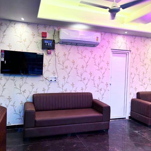 a living room with a couch and a wall at Hotel Om Palace in Mathura