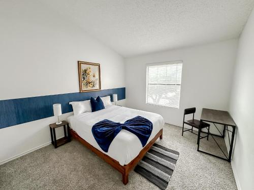 オースティンにあるSleepover 1BD 1BA Austin TX Apartmentsのベッドルーム1室(青いヘッドボード付きのベッド1台、デスク付)
