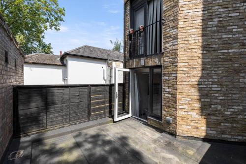 a brick house with a gate and a balcony at Perfect Flat Next To Highgate Station in London