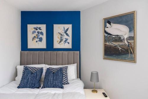 a bedroom with blue walls and a bed with blue pillows at Perfect Flat Next To Highgate Station in London