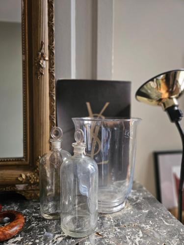 two glass vases and a lamp on a table at Suite privée Terreaux in Lyon