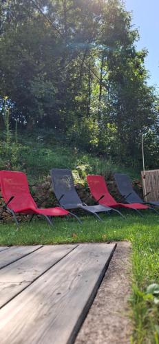 three chairs sitting in the grass next to a wooden deck at AUSZEIT am Steinbichl in Feistritz am Wechsel