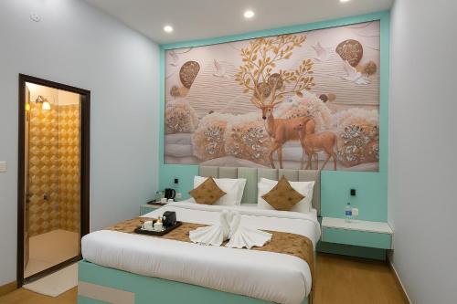 a bedroom with a large bed with a painting on the wall at Siya Resort Ayodhya - Comfortable Rooms & Luxury Stay Near Ram Mandir in Ayodhya