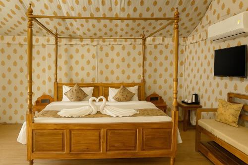 a bedroom with a canopy bed with white sheets at Siya Resort Ayodhya - Comfortable Rooms & Luxury Stay Near Ram Mandir in Ayodhya