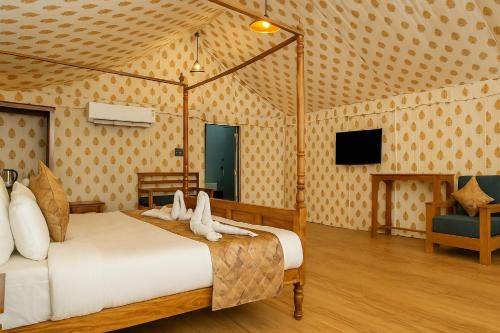 a bedroom with a bed and a tv in a room at Siya Resort Ayodhya - Comfortable Rooms & Luxury Stay Near Ram Mandir in Ayodhya
