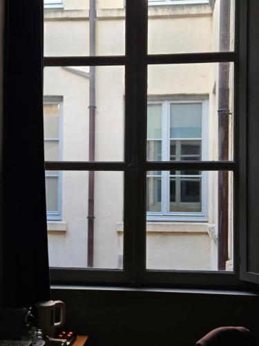 an open window with a view of a building at Suite privée Terreaux in Lyon